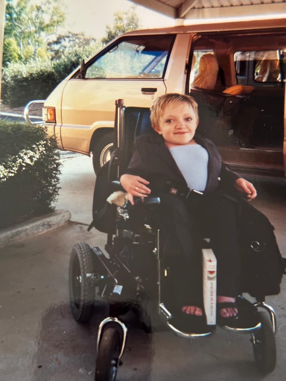 Stella in her wheelchair next to a van
