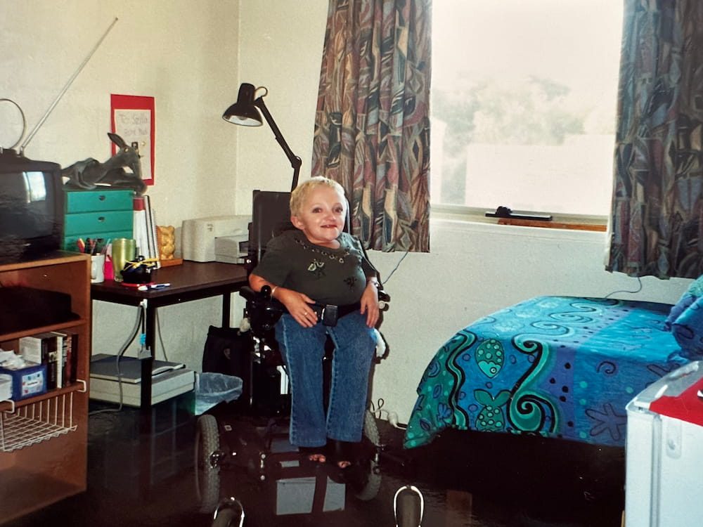Stella in her dorm room at Deakin University. The room is taken up with a bed and a desk.